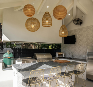 An outdoor kitchen with a built-in grill, sink, and stylish lighting installed by FITZ Construction in Kenner, LA.