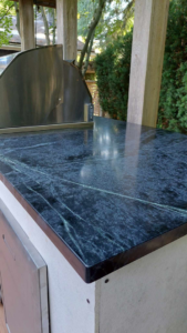 Close-up of a dark green marble-look outdoor kitchen countertop by Eagle Outdoor Living LLC in Freeland, WA.