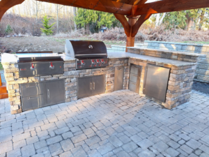 A complete outdoor kitchen with pergola and paver patio installed by Eagle Outdoor Living LLC in Freeland, WA.