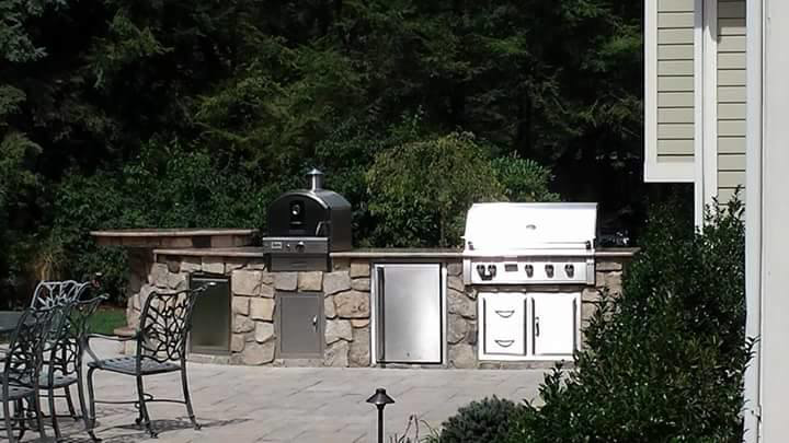 An outdoor kitchen featuring a built-in pizza oven and granite countertops by LJ Marble & Granite in Paterson, NJ.