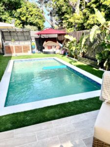 A newly installed outdoor kitchen and swimming pool, showcasing a complete backyard transformation by BAFCO POOLS in Hialeah, FL.