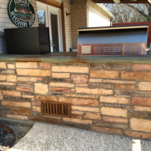 An outdoor kitchen with stone veneer and a built-in grill by Mason Contracting in Levittown, PA.