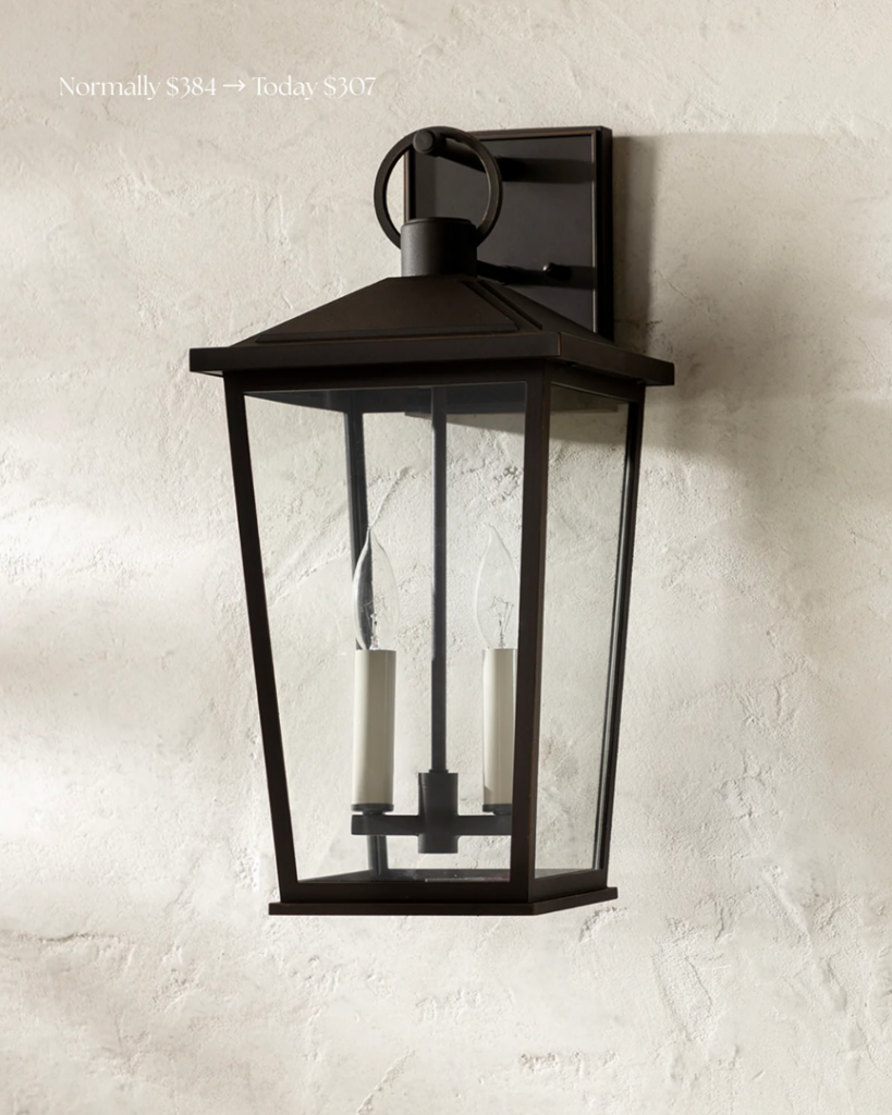 A dark bronze outdoor lantern light fixture mounted on a textured wall, representing exterior lighting services by Wiersma Homes in Knoxville, TN.