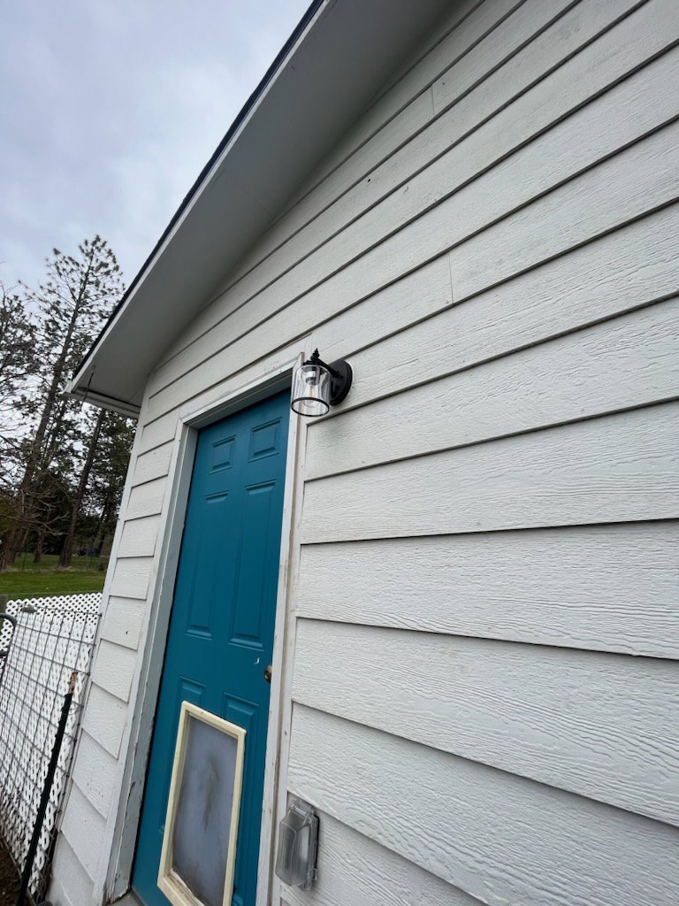 Newly installed outdoor light fixture on a white siding wall, showing electrical work by Epic Electric, Heating, Cooling & Plumbing in Spokane, WA