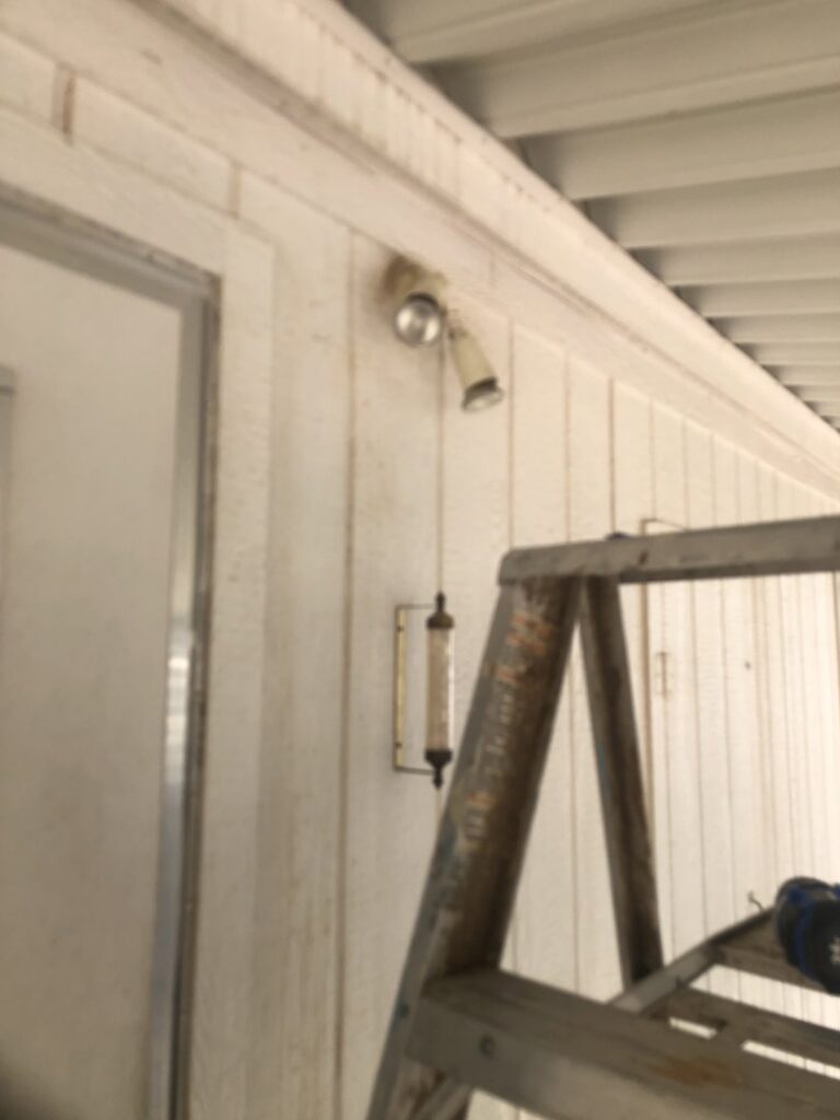 A ladder positioned next to a house wall for outdoor light fixture repair or replacement by Mancusi Home Maintenance in Boulder City, NV.