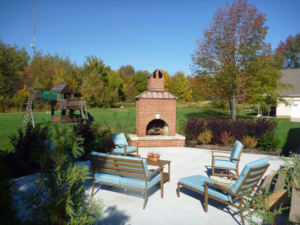 A newly constructed outdoor patio with a brick fireplace by Paris Brothers & Company, Inc in Erie, PA