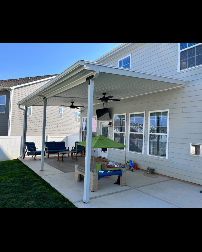 A newly installed outdoor patio cover with ceiling fans and a mounted TV by Sundown General Contracting in Mooresville, NC.
