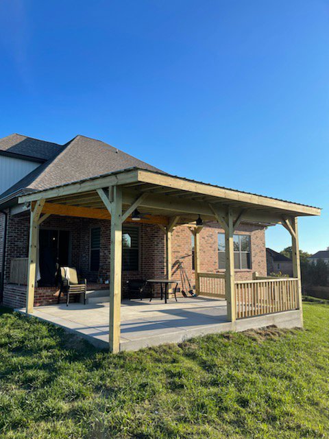 A newly constructed outdoor patio cover or pergola with a wooden frame, built by Huff Consolidated Enterprises LLC in Clarksville, TN.