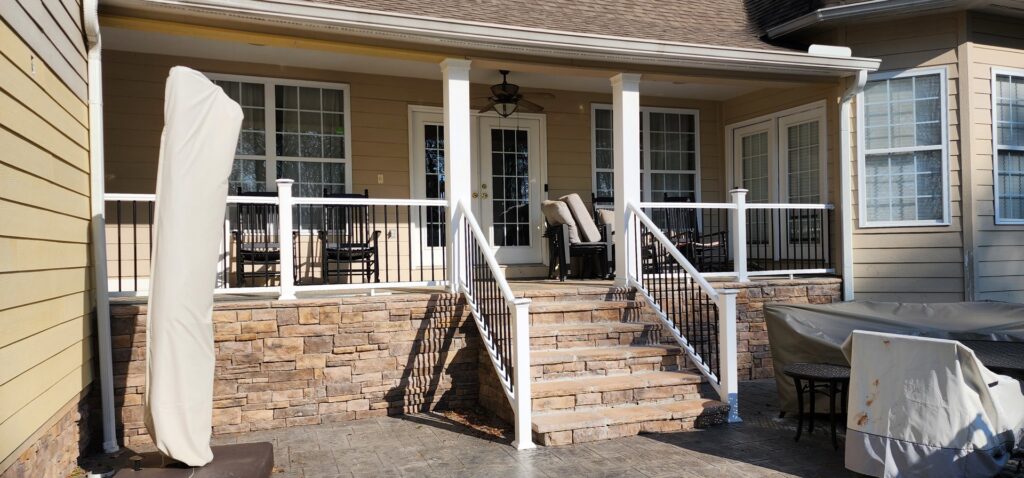 A renovated outdoor patio and covered porch with stone facade and new railings by Rapid Repairs and Renovations in Knoxville, TN.