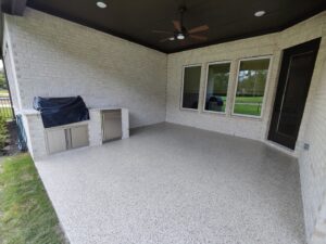An outdoor patio with a speckled epoxy floor and built-in grill, completed by Simply Construction in Las Vegas, NV.