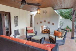 An inviting outdoor patio with a cozy fireplace and comfortable seating by Homework Remodels in Phoenix, AZ.