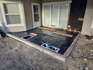 An outdoor patio foundation under construction with a vapor barrier by Constructed by 360 LLC in Meridian, ID.