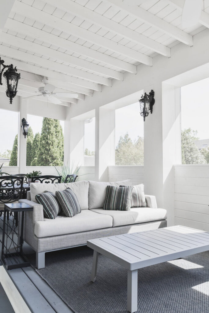 A bright outdoor patio with painted ceiling, furniture, and wall sconces by Harpeth Painting, LLC. in Nashville, TN.