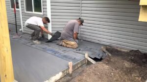 Workers installing outdoor patio pavers for Waldron Construction, Kitchen & Bath in Antioch, IL