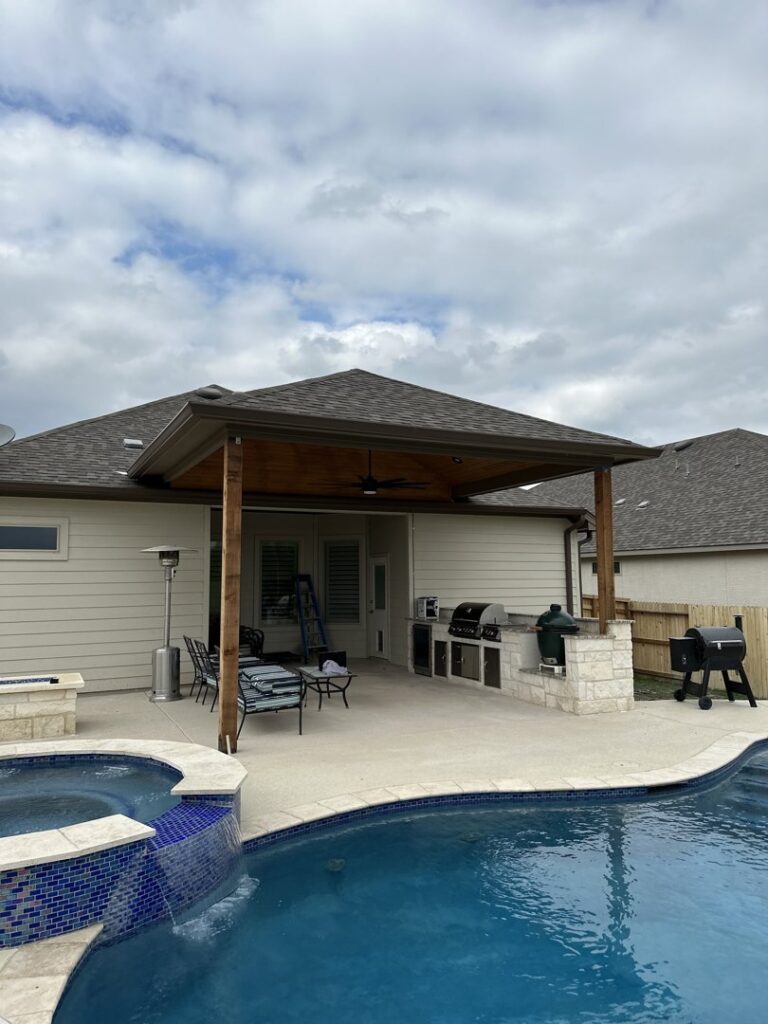 A completed outdoor patio and pool area with a covered kitchen by PaRu Construction LLC in San Antonio, TX
