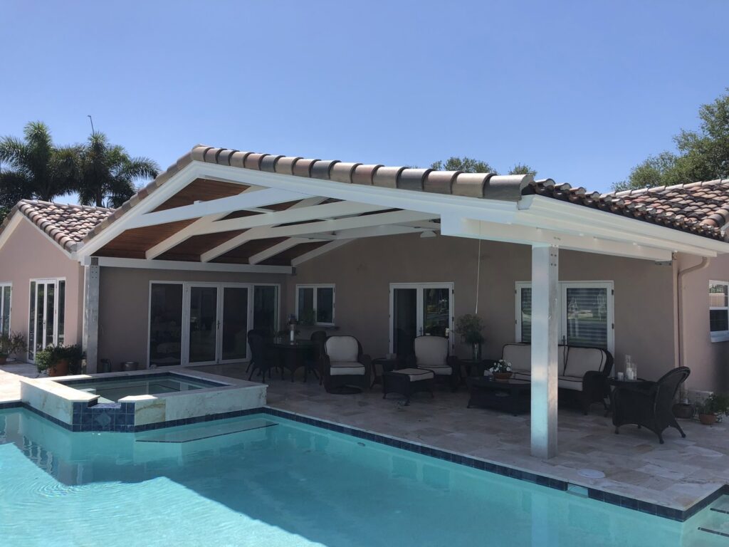 An inviting outdoor patio with a swimming pool and a large covered pergola, a construction project by Pioneer Built in St. Petersburg, FL.