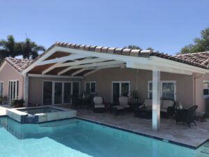 An inviting outdoor patio with a swimming pool and a large covered pergola, a construction project by Pioneer Built in St. Petersburg, FL.