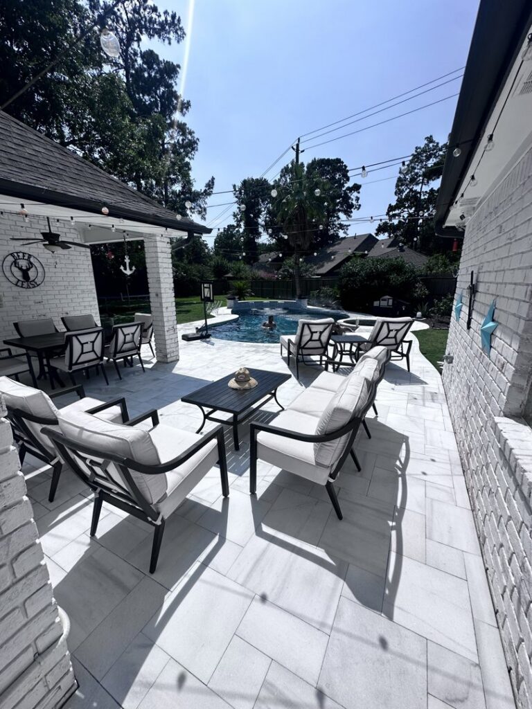 An inviting outdoor patio seating area with a view of a custom pool, designed by Limitless Custom Pools and Backyards in Houston, TX.