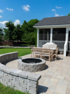 An outdoor patio with a stone fire pit and seating area built by Mr. GreenJeans in Indianapolis, IN.