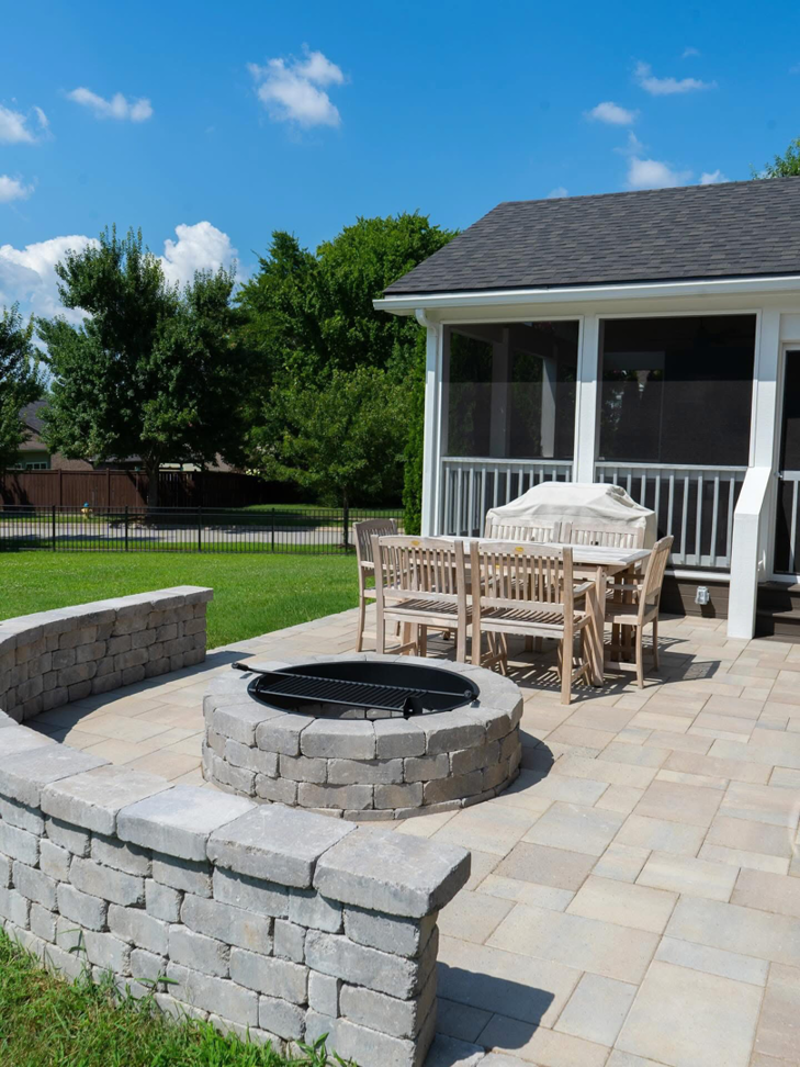 An outdoor patio with a stone fire pit and seating area built by Mr. GreenJeans in Indianapolis, IN.