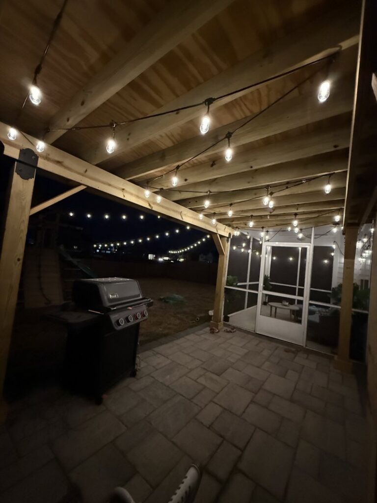 An inviting outdoor patio with stylish string lights professionally installed overhead by Lights Made Easy of Charleston, SC