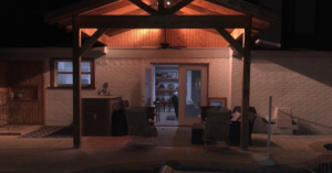 An illuminated outdoor patio with a newly built wooden pergola by Mason Contracting in Levittown, PA.