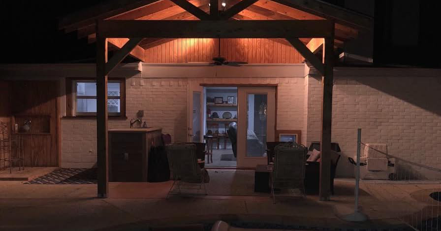 An illuminated outdoor patio with a newly built wooden pergola by Mason Contracting in Levittown, PA.
