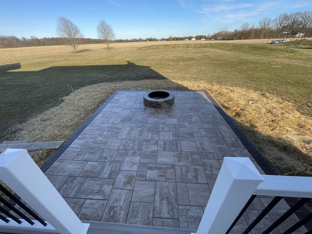 A beautiful outdoor paver patio with a built-in fire pit, expertly installed by Inspired Renovation & Hardscape's in Lorain, OH.