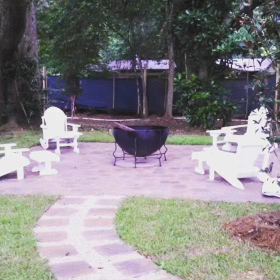 An inviting outdoor paver patio with a fire pit and seating, designed and built by Keystone Design in Tallahassee, FL.