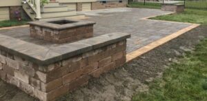 A newly installed outdoor paver patio with a built-in fire pit, a service offered by Huntington Home Repair in Huntington, WV.