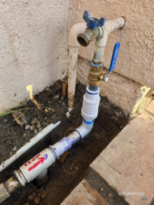 New outdoor plumbing installation with a shut-off valve and PVC pipe by Bakoboy Enterprise Inc in Bakersfield, CA.