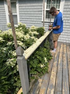 A newly installed outdoor shower with plumbing visible against house siding by Woodbine Repair & Remodeling in Jamestown, RI.