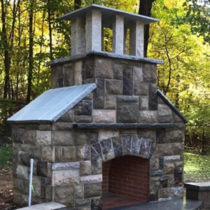 An outdoor stone fireplace and oven structure built by Tomori's masonry llc in Cheshire, CT