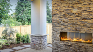 An outdoor living space featuring a modern stone fireplace and patio installed by Punchlistit in Lenexa, KS.