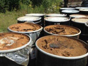 Outdoor storage of multiple hazardous waste drums, handled by MLi Environmental in South Portland, ME.