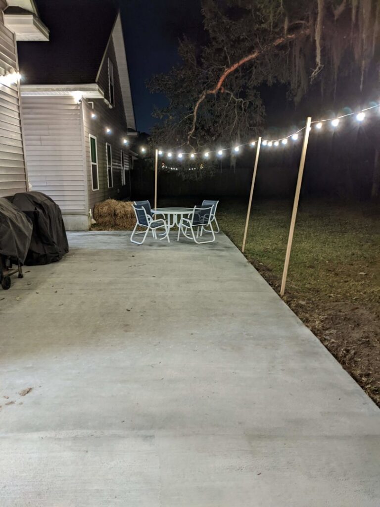 Outdoor string lights installed over a concrete patio by Half Moon Custom Homes, your handyman in Rincon, GA.