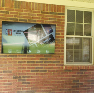 Expert outdoor TV installation on a textured brick wall by Tvbypass in Jackson, TN.