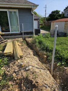 An outdoor trench with pipes and lumber, indicating utility line installation by Paramount Development in Milwaukee, WI.