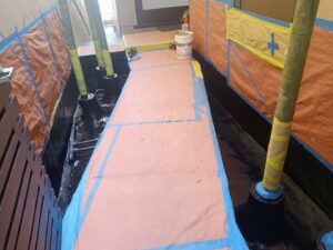 Outdoor walkway area with waterproofing and protective sheeting applied by Juancho's Handyman in Salida, CO.