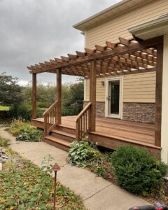 A newly built outdoor wood deck with an overhead pergola structure, constructed by Orion Construction Services in Duluth, MN.