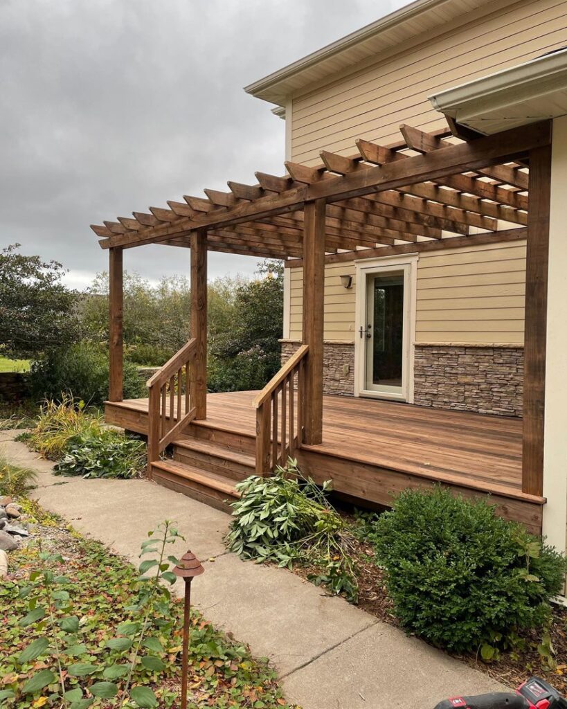A newly built outdoor wood deck with an overhead pergola structure, constructed by Orion Construction Services in Duluth, MN.