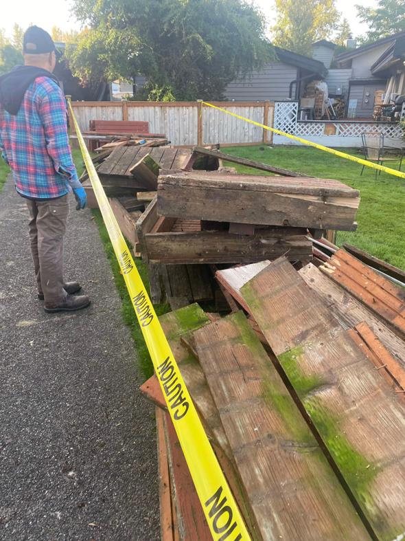 Outdoor wooden debris pile with caution tape, awaiting junk removal by Adept Junk Removal Services LLC in Tacoma, WA.