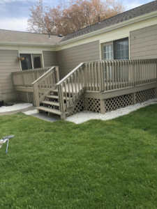 Outdoor wooden deck with stairs and lattice skirting, freshly stained by Kings Handyman Services in Dallas, TX