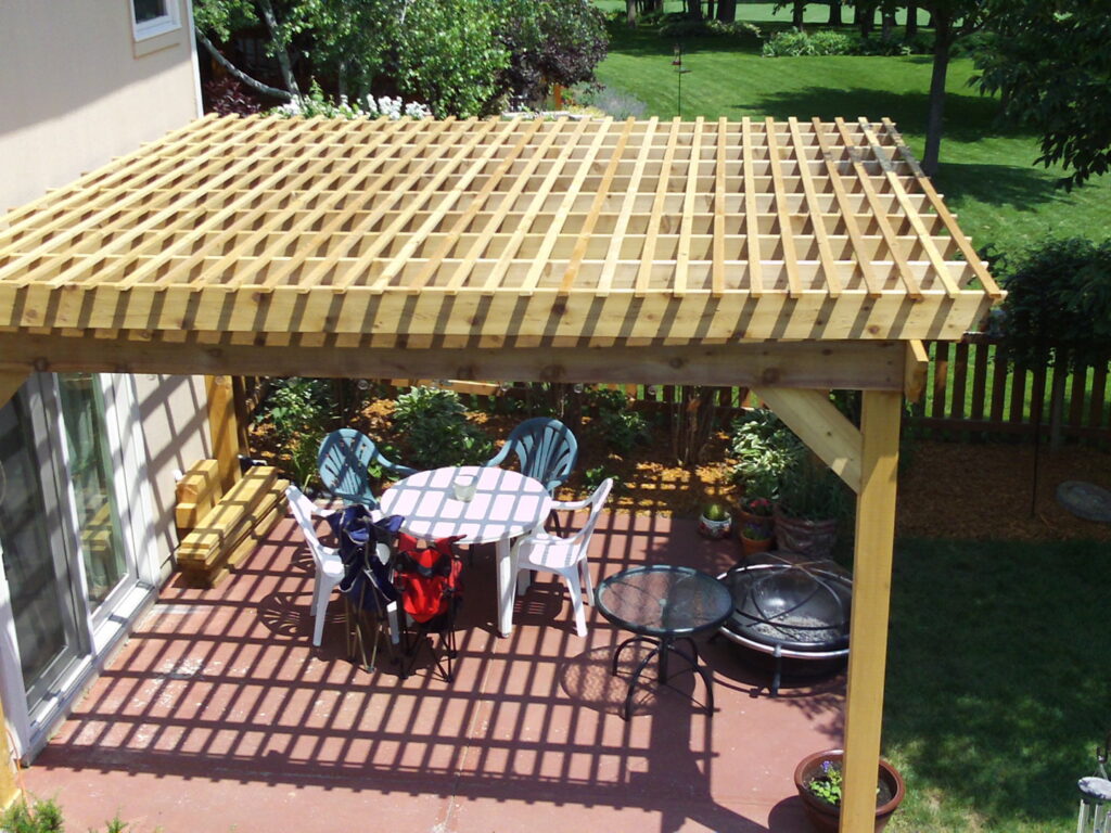 A newly constructed outdoor wooden pergola covering a patio area by Handyman Joe in Omaha, NE