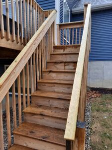 Outdoor wooden stair repair or replacement in progress, showing new and old wood, by Woods Builders in Grand Rapids, MI.