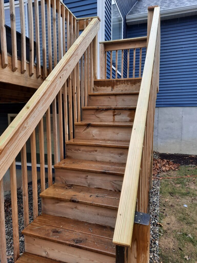 Outdoor wooden stair repair or replacement in progress, showing new and old wood, by Woods Builders in Grand Rapids, MI.