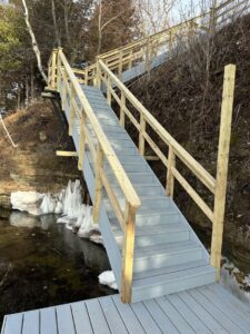 Newly constructed outdoor wooden stairs leading down a natural slope by Wildflower Landscapers LLC in Larsen, WI