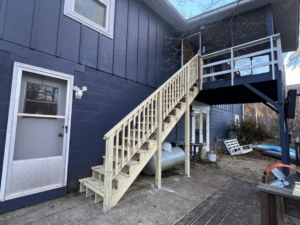 Full view of new outdoor wooden stairs leading to a deck, built by Shepard Remodeling in Huntsville, AL.