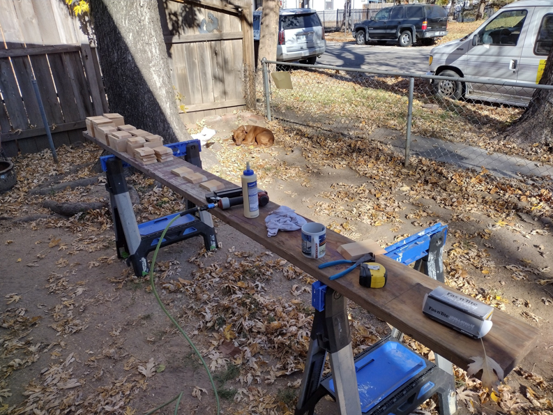 An outdoor workbench with wood pieces, glue, and tools ready for a project by Do-N-All Handyman Service in Wichita, KS.