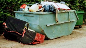 A large, overflowing dumpster filled with various debris and trash, indicating a significant junk removal project handled by Trash Monkey Junk Removal in Charleston, WV.